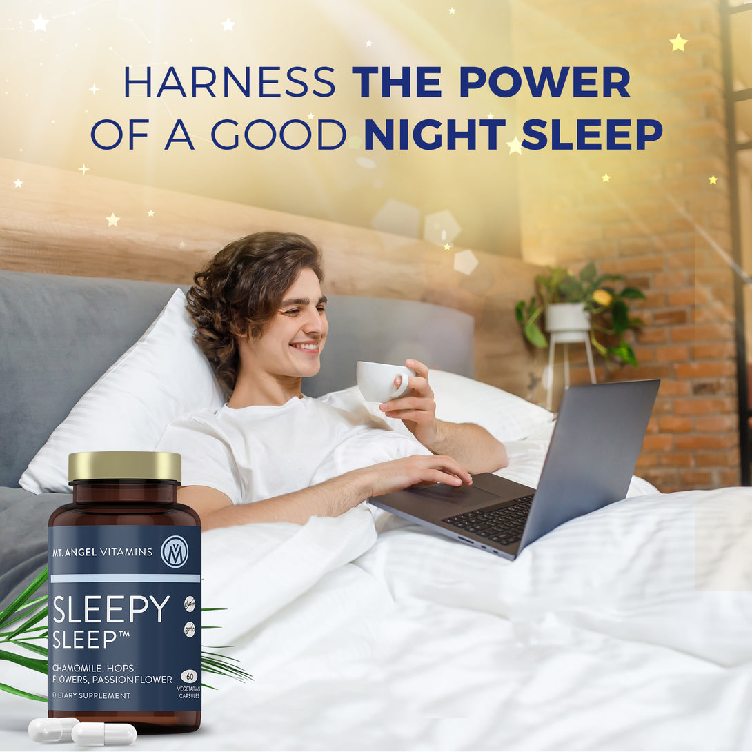 A Blue bottle of Mt. Angel Vitamins Sleepy Sleep is shown in front of a man feel rested and happy in his bed. He is drinking a cup of coffee and working on his laptop cheerfully after waking up from a good night's sleep thanks to Mt. Angel Vitamins Sleepy Sleep. The tagline reads Harness the Power of a Good Night Sleep.