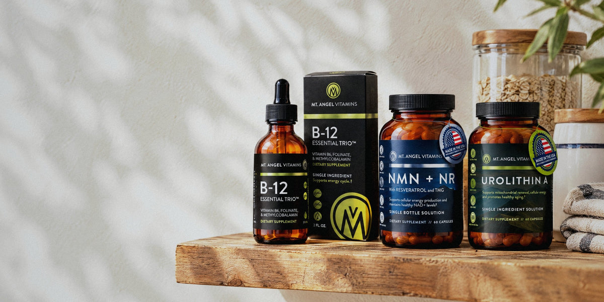 Mt. Angel Vitamins B-12 Essential Trio, NMN + NR and Urolithin A on a sunlit wooden shelf