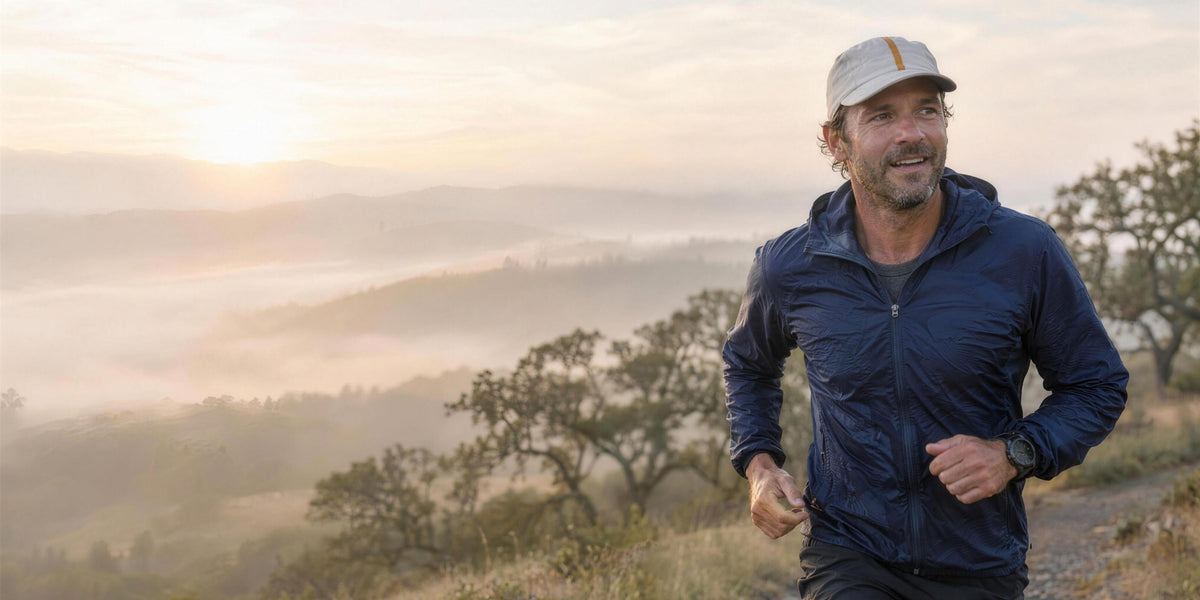 A man in his forties running a misty Oregon oak-savanna trail at sunrise
